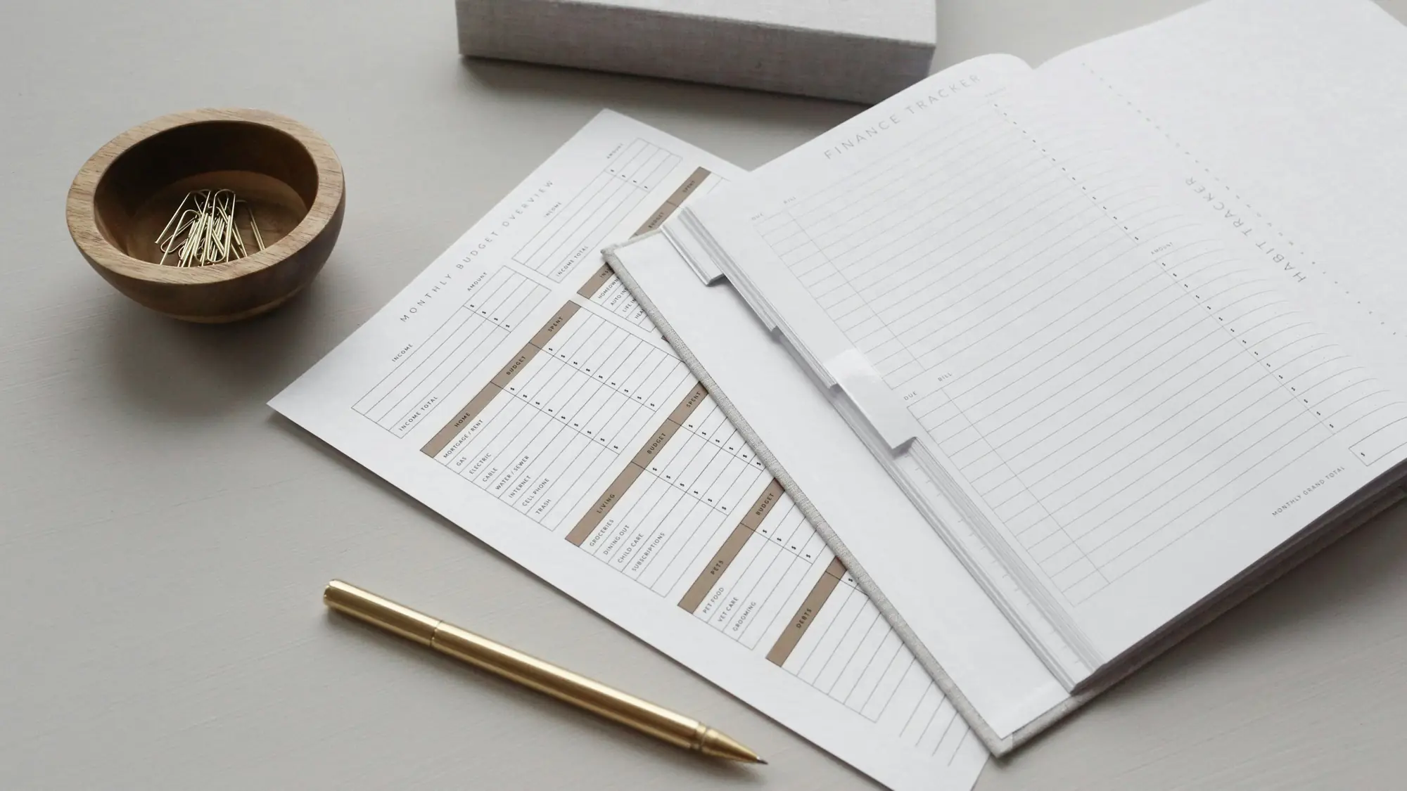 Neatly arranged papers and a gold pen on a desk